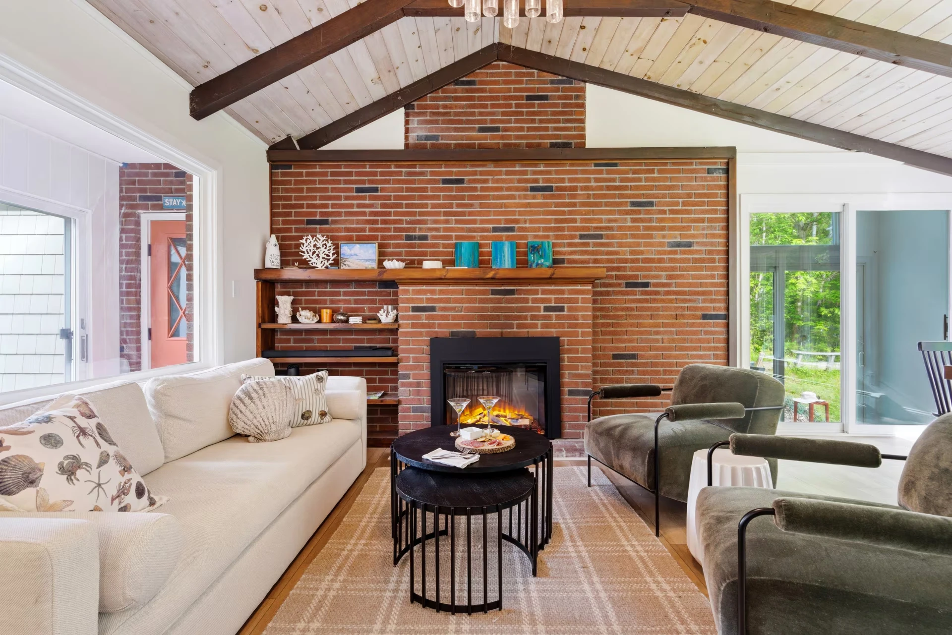 Spacious living room with exposed brick fireplace at HoWells Landing in Wells, ME